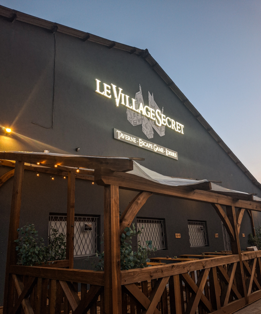 Enseigne Le Village Secret sur façade extérieure